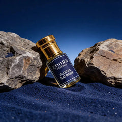 Zoura Floral Safrane Attar bottle styled on blue sand with rocks – unisex non-alcoholic perfume oil