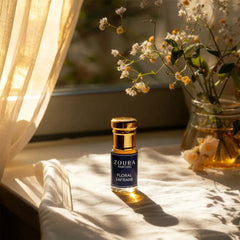 Zoura Floral Safrane Attar bottle in sunlight on windowsill with wildflowers – unisex non-alcoholic attar