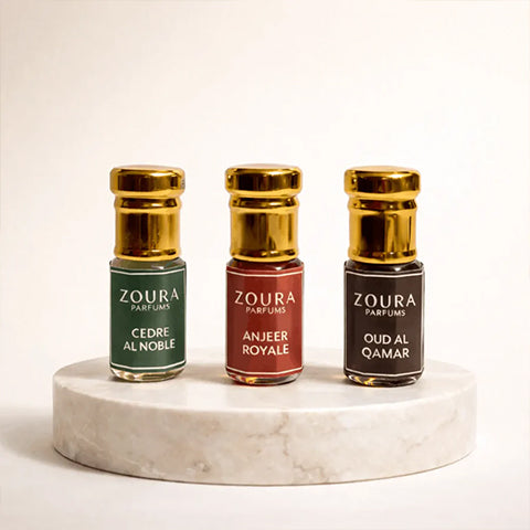 Three Zoura Attars on a marble stand with a white background