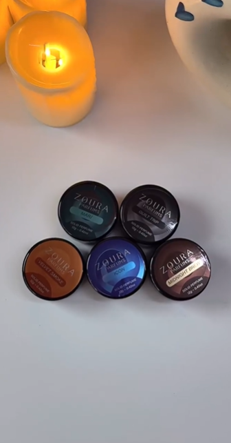Solid perfume 12g balm in compact jar, pink texture, applied with fingertip near lit candles
