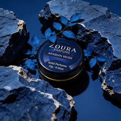 Arabian Musk solid perfume by Zoura Parfums on rocks with foliage