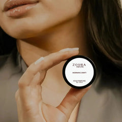Woman holding Zoura Parfums Morning Drift Unisex Solid Perfume jar near neck
