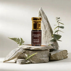 Zoura Parfums Oud Al Qamar attar bottle on natural stone with eucalyptus and greenery