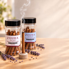 Zoura Oud Zahabi mini bakhoor incense sticks combo, Oud Noir and Oud Eclat jars with a burning stick and lavender on a wooden table
