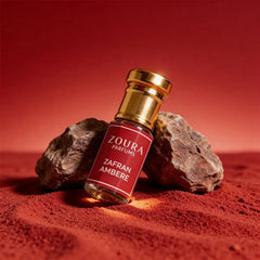 Zoura Zafran Amber Attar bottle on red sand with rocks – luxury unisex amber attar